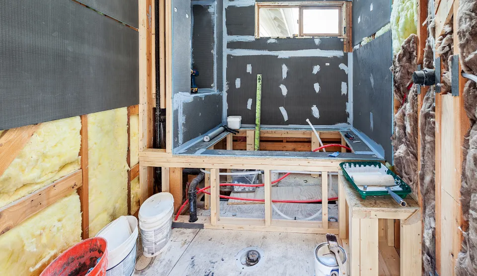 Bathroom addition under construction with new framing, insulation, plumbing rough-in, and waterproofing panels installed for a Los Angeles home