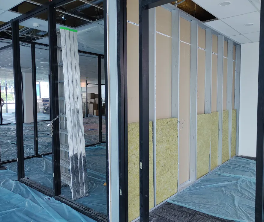 Commercial construction process showing metal framing and insulation being installed