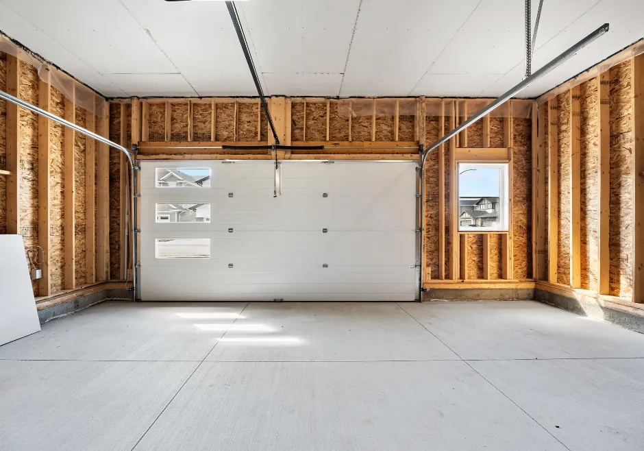Garage conversion before construction showing unfinished walls and concrete flooring