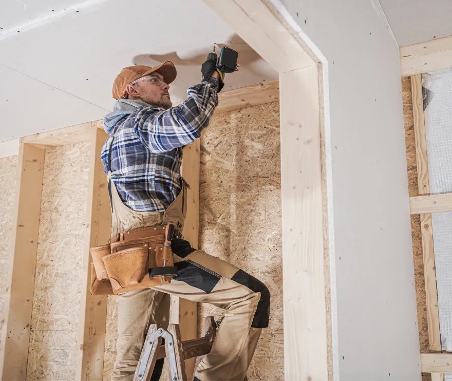 Professional contractor installing drywall during a room addition project in Los Angeles